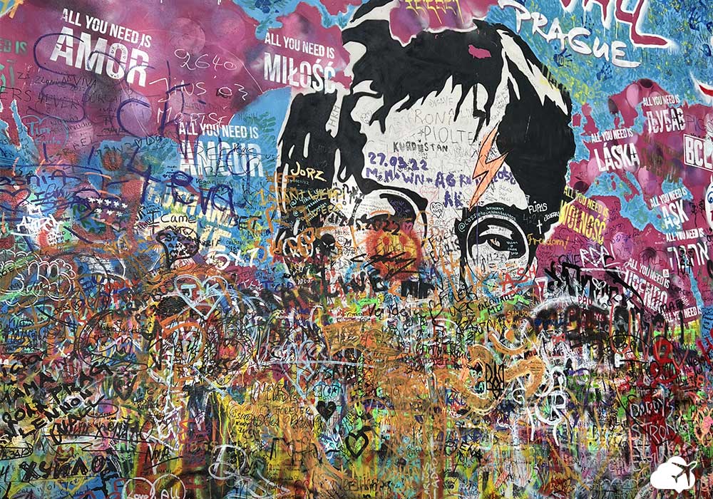 Muro pintado com o rosto de John Lennon e diversas frases