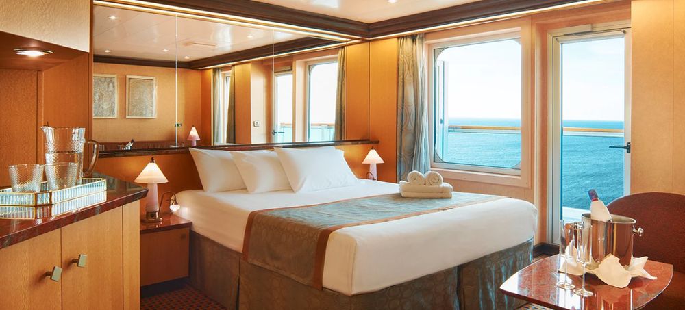 foto da suite do navio Favolosa com cama e vista para o mar